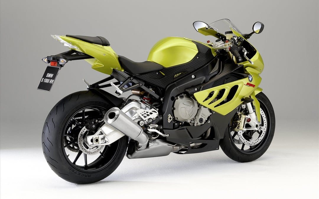 Acid green BMW S 1000 RR motorcycle from a rear angle against a neutral grey studio background with soft lighting.