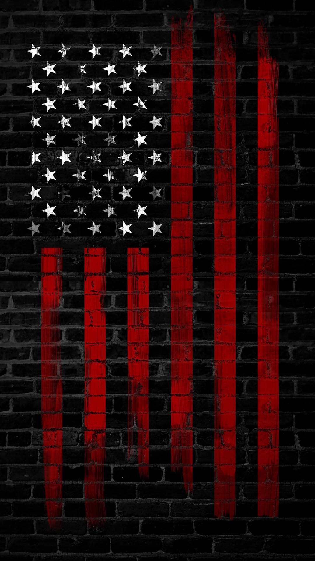 Distressed American flag painted on a dark brick wall with visible masonry texture and white stenciled stars.