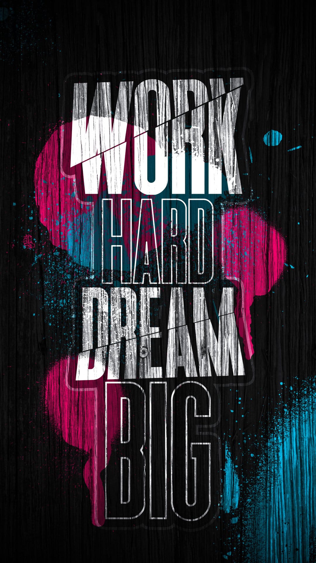 White distressed Work Hard Dream Big lettering on dark wood with vibrant pink and blue spray paint splatters.