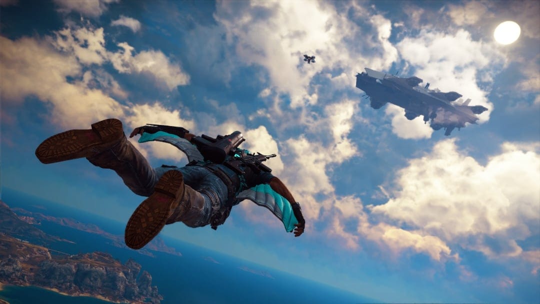 Man in a blue wingsuit flying above a tropical ocean near a giant armored airship under a bright sunny sky.
