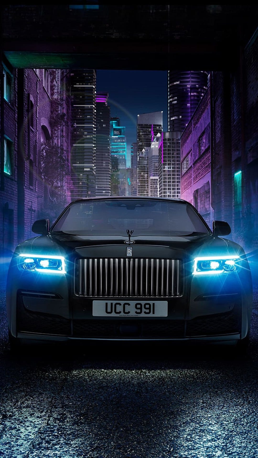 Rolls-Royce Ghost with glowing headlights parked on a wet street surrounded by vibrant neon city skyscrapers.