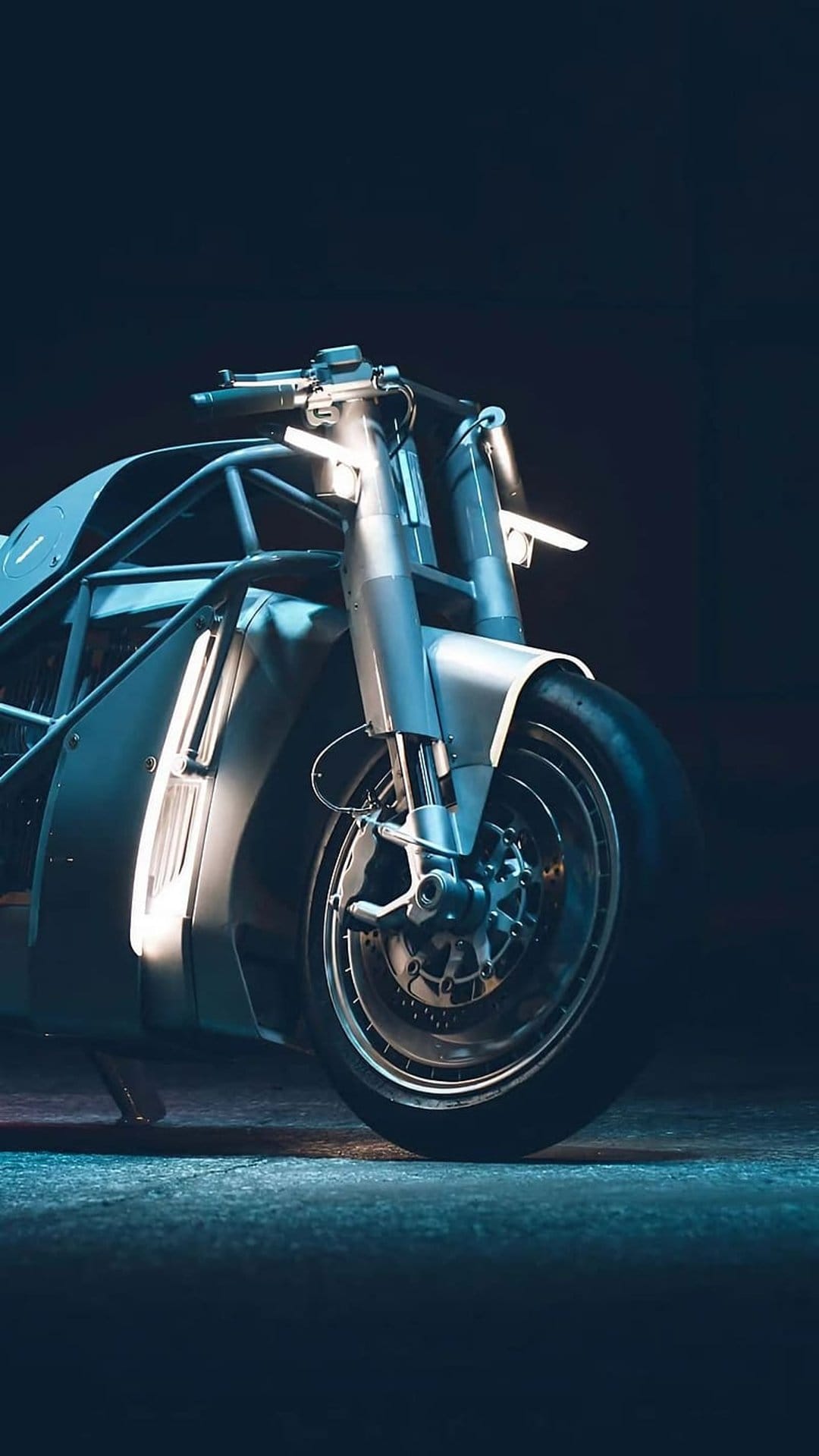 Electric motorcycle with glowing blue LED strips on the front forks and a large alloy wheel in a dark setting.