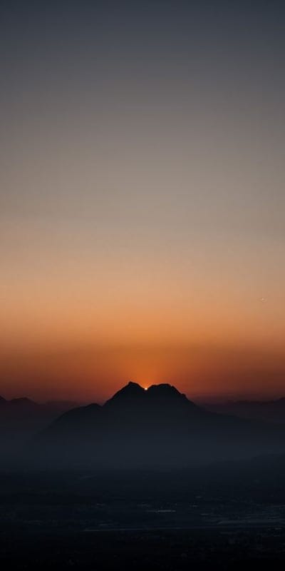 Sunset, Mountain, Silhouette, Horizon, Serene, Golden hour, Nature, Landscape, Twilight, Dramatic, Peaceful, Orange sky, Scenic, Dusk, Natural beauty, Calm, Outdoors, Mountain range, Sublime, Sky