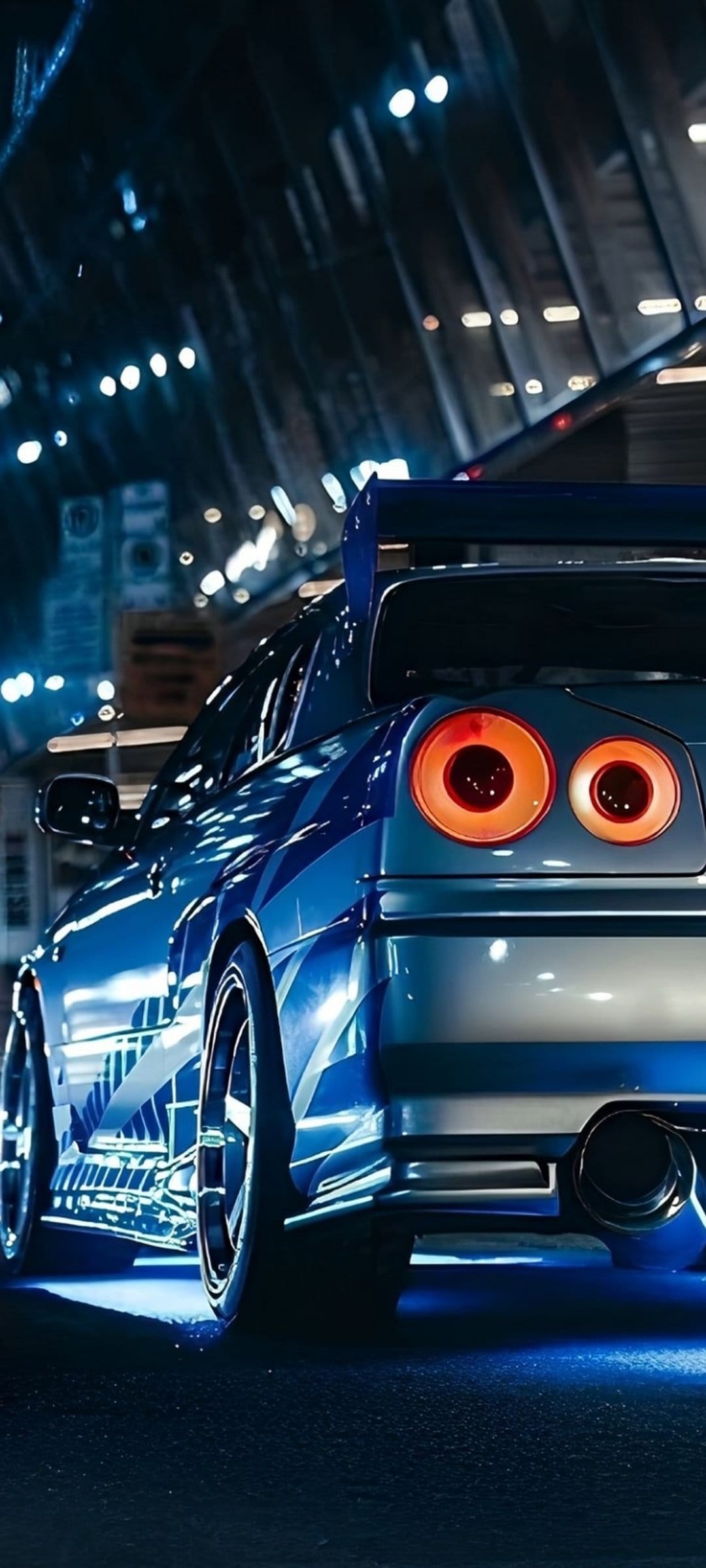 Blue sports car with a large spoiler and round taillights parked on a dark road in a glowing neon city at night.