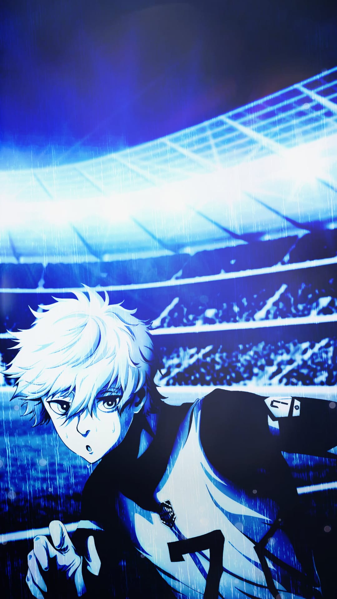 White-haired soccer player sprints across a rain-slicked stadium field illuminated by neon blue lights at night.