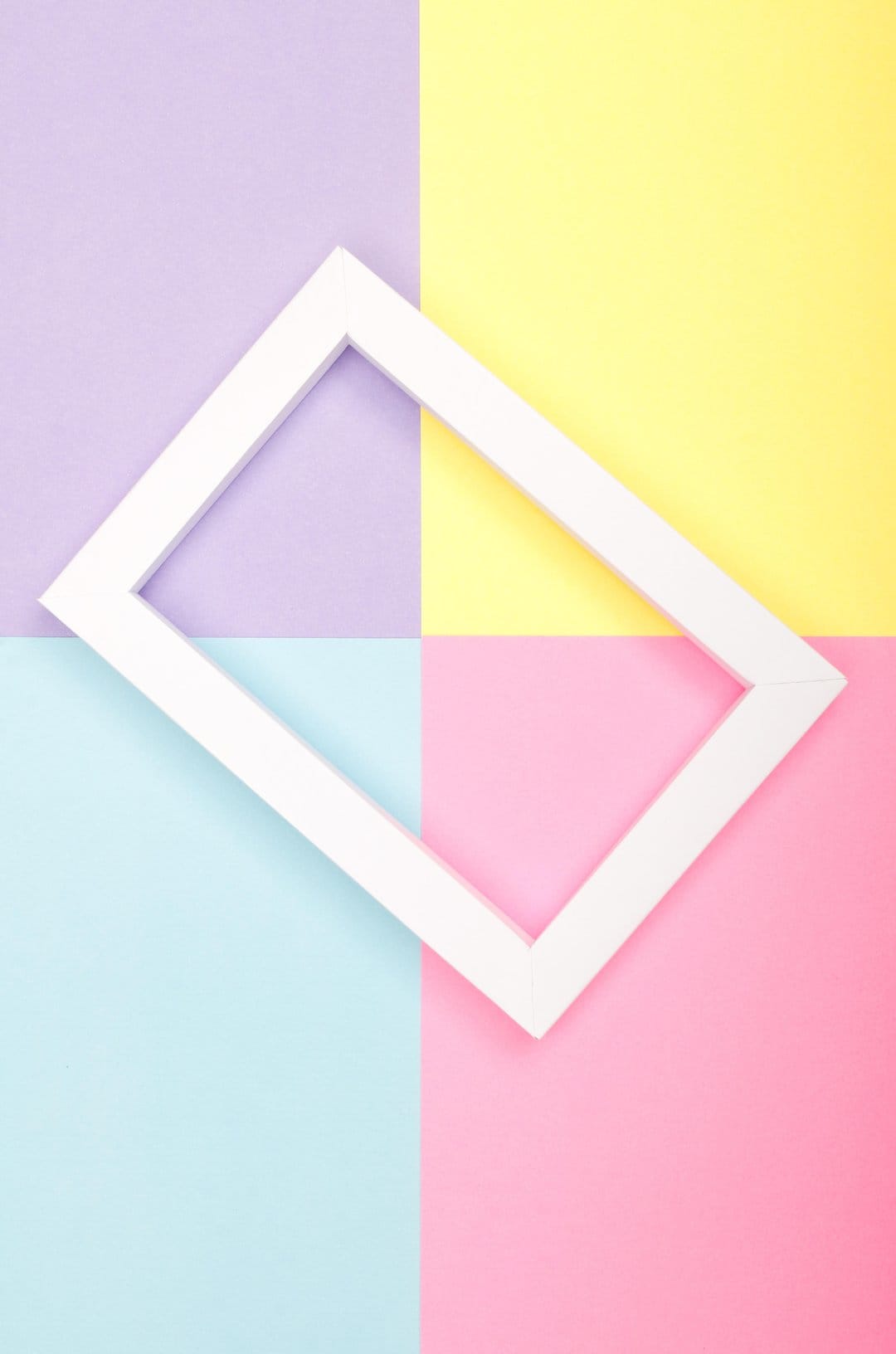 White diamond frame positioned diagonally over a soft-toned geometric grid with four distinct pastel colors.