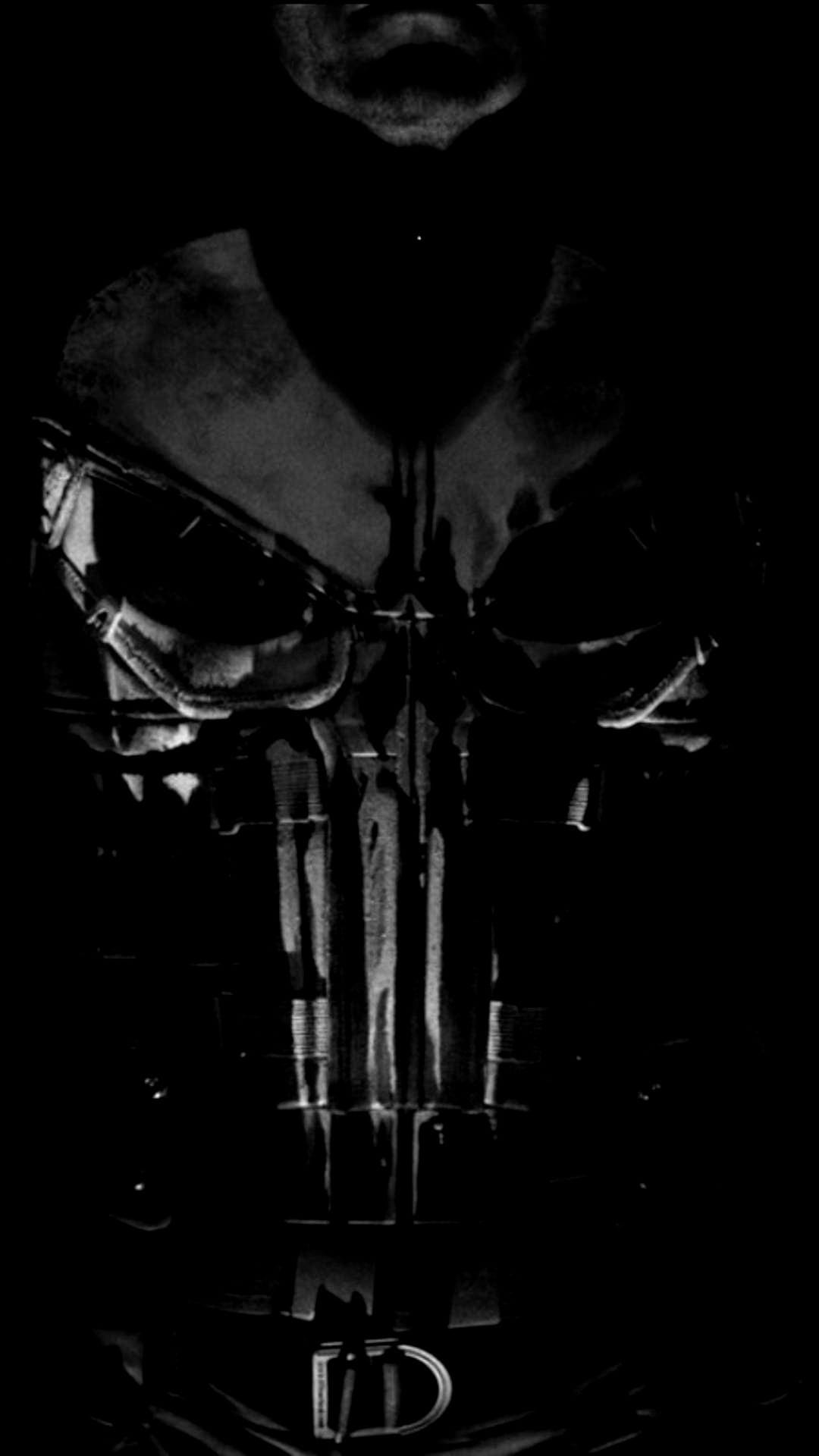 Punisher skull insignia on a textured tactical chest plate with deep shadows and a metallic belt buckle detail.
