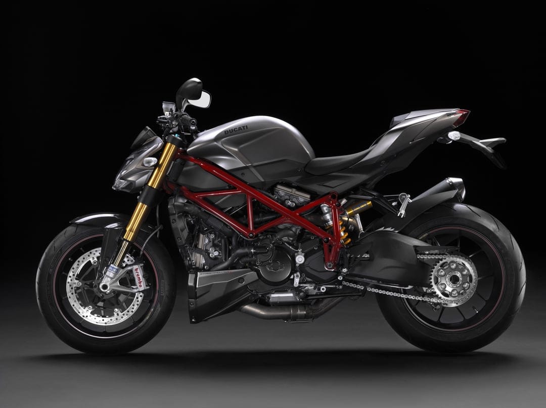Ducati Streetfighter S motorcycle with matte grey body and red trellis frame against a dark background.