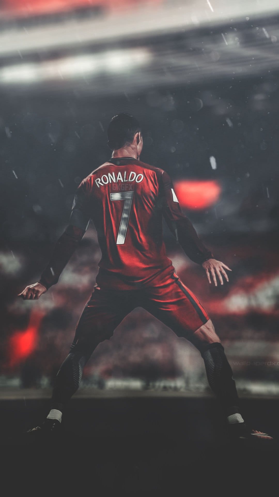 Cristiano Ronaldo stands in a rainy dark stadium wearing a red Manchester United jersey with number seven.