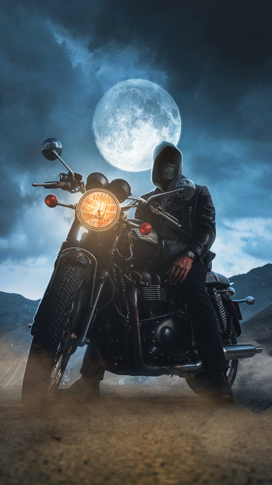 Biker wearing a skull mask sits on a motorcycle beneath a massive full moon amidst dark mountain silhouettes.