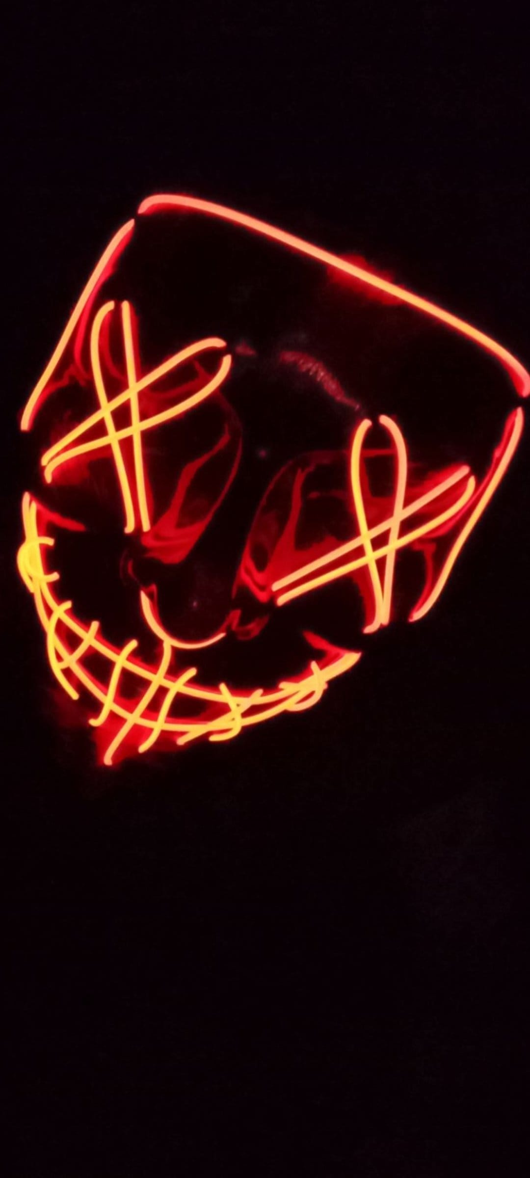 Purge mask featuring glowing red and yellow neon wire stitches over the mouth and eyes against a black background.