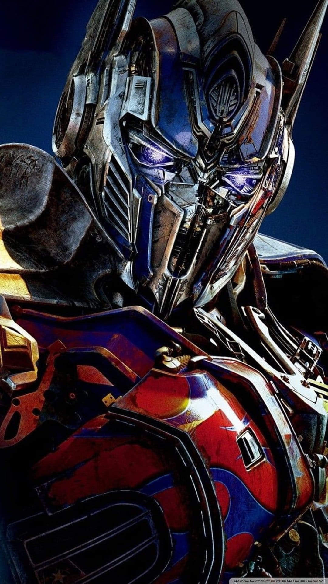 Optimus Prime shows detailed red and blue armor with glowing sapphire eyes in a close-up mechanical portrait.