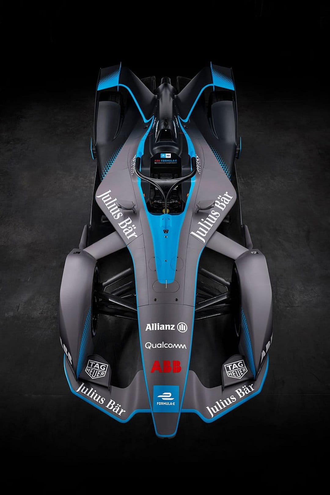 Formula E race car viewed from above with grey and blue aerodynamic bodywork featuring various sponsor logos.