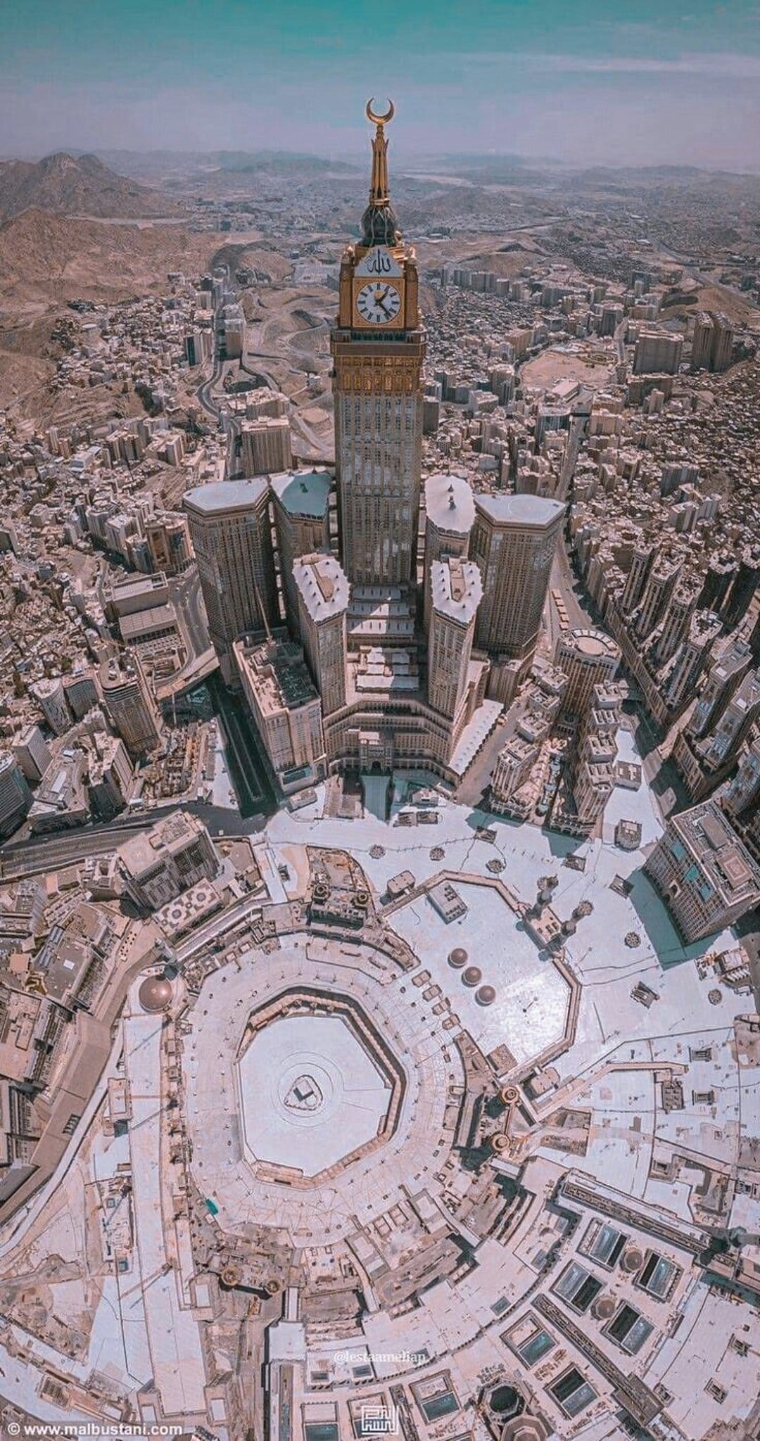 Abraj Al-Bait Clock Tower overlooks the Kaaba and Masjid al-Haram courtyard from an elevated aerial perspective.