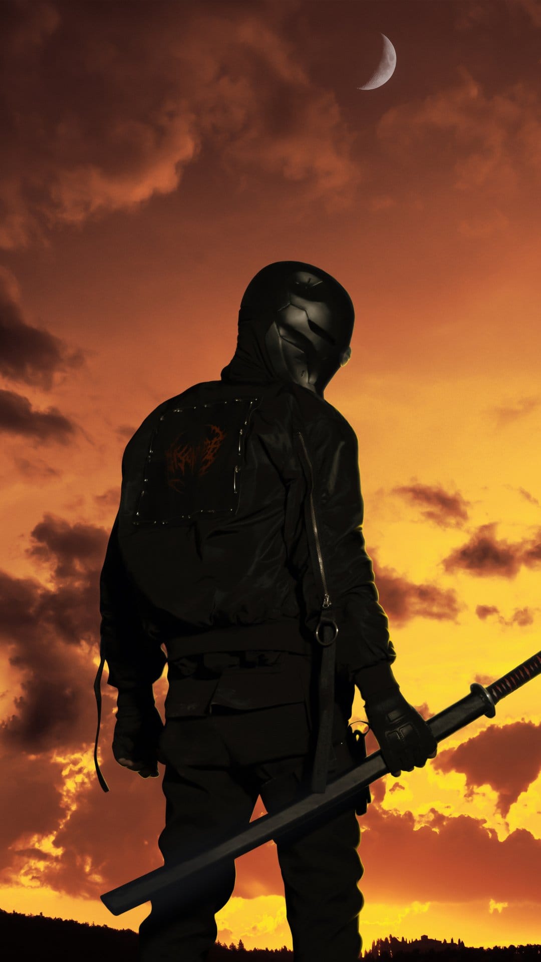 Ninja warrior in a black helmet holding a katana against a red sunset sky with a visible crescent moon.