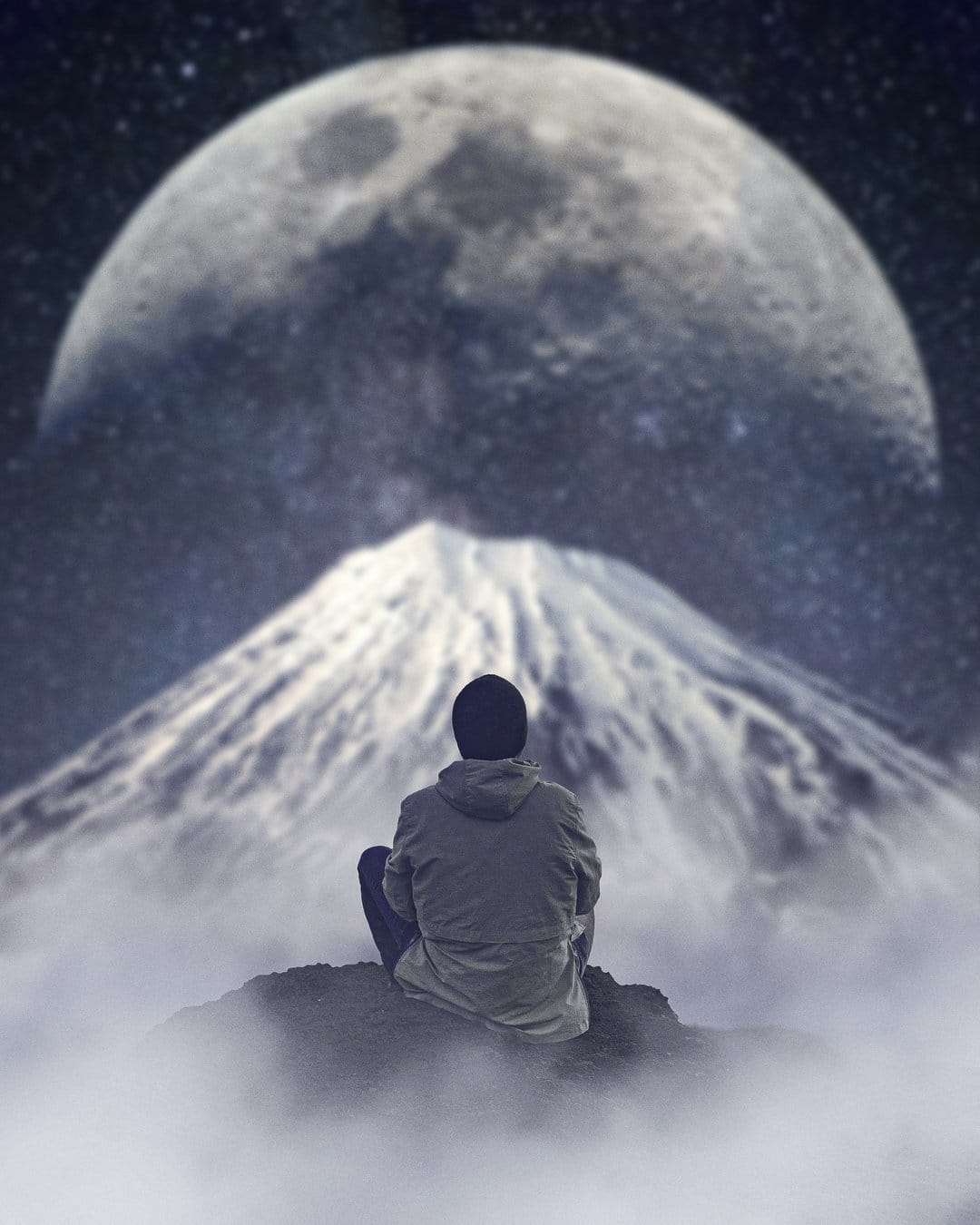 Silhouetted figure sits on a rocky ridge facing a massive full moon above jagged, snow-covered mountains.