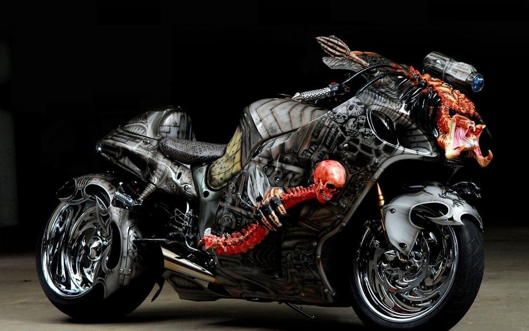 Predator motorcycle fairing with detailed skeleton airbrushing and chrome accents on a dark custom street bike.