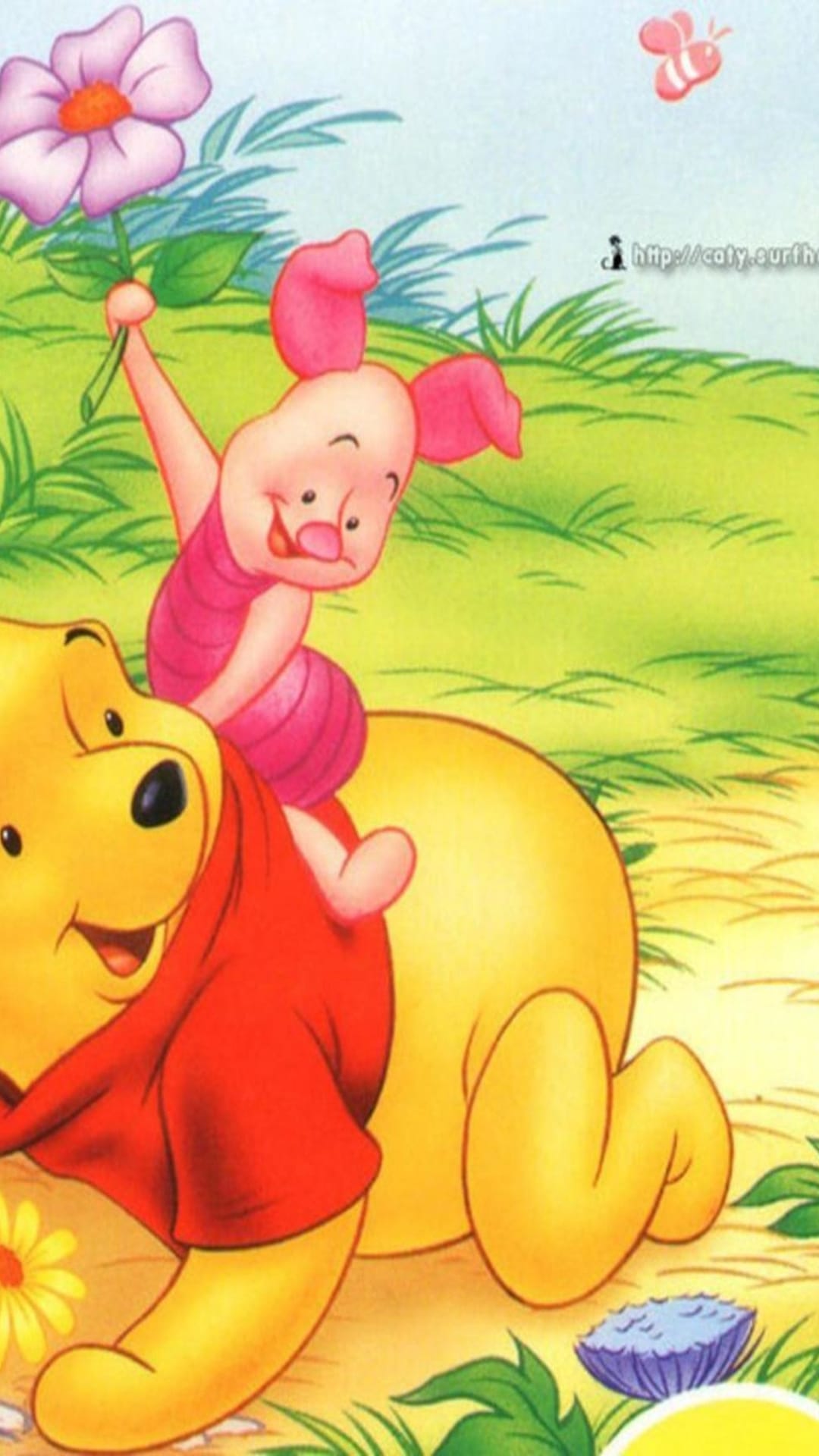 Winnie the Pooh and Piglet stand in a green field as Piglet holds a pink flower under bright summer sunlight.
