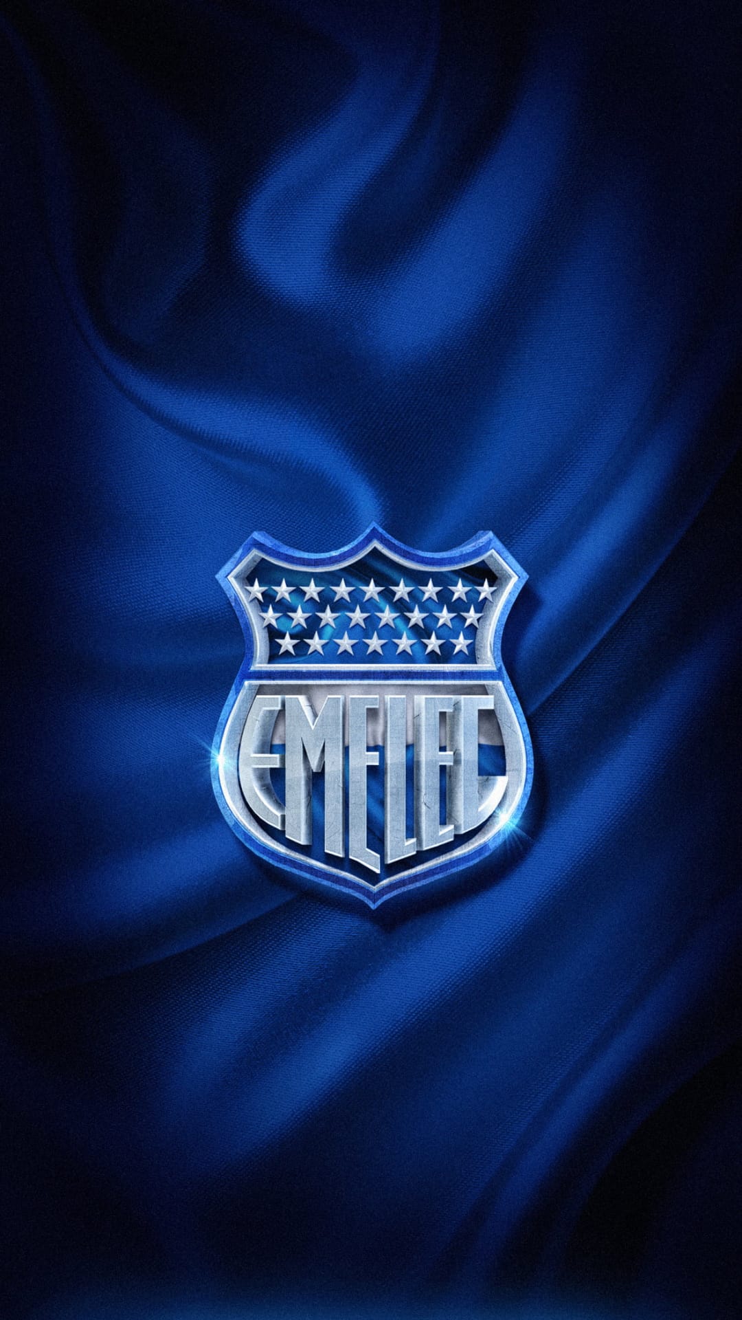 Emelec club crest featuring stars and a metallic shield centered on draped dark blue satin fabric with soft highlights.