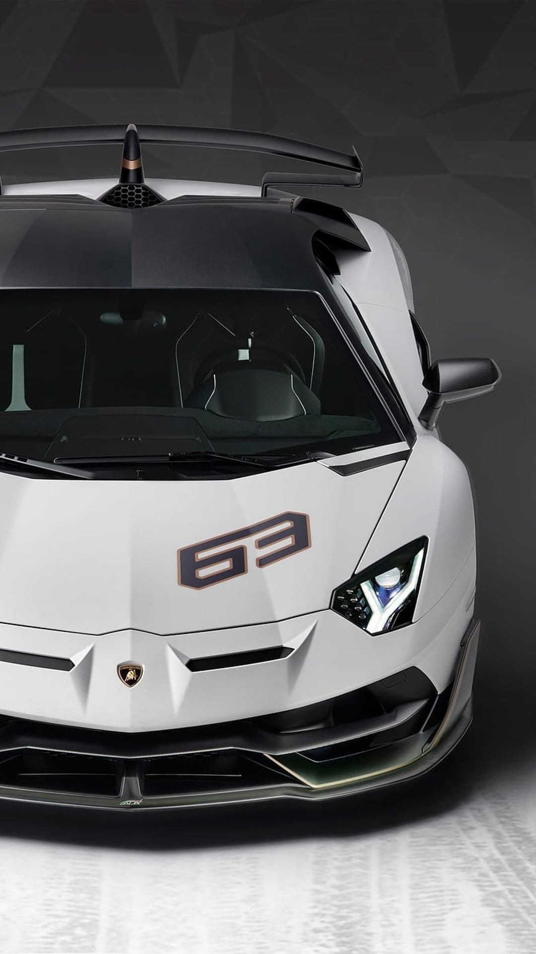 White Lamborghini Aventador SVJ 63 front view showing sharp LED headlights and aerodynamic matte black accents.