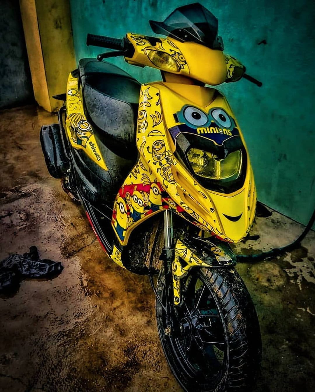 Yellow scooter featuring Minion character graphics and custom bodywork decals in a vertical portrait view.