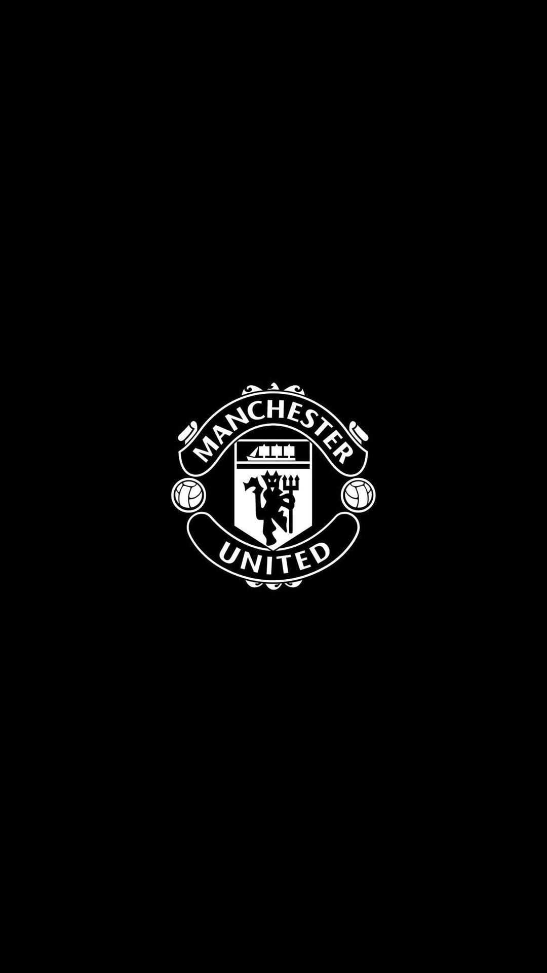 Manchester United white crest with a ship and devil symbol centered on a solid black vertical background.